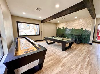 A room with a pool table and a shuffleboard table.